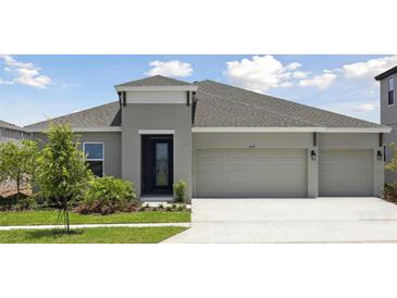 Charming single-story home with a manicured lawn, inviting entrance, and a spacious three-car garage at 5178 Everlong Dr, Apollo Beach, FL 33572