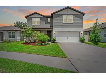 Beautiful two-story home with a well-manicured lawn and an attached two-car garage at 6248 Bradford Woods Dr, Zephyrhills, FL 33542