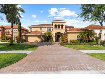 Stunning Mediterranean home with a tile roof, brick driveway, and lush landscaping at 8358 Dunham Station Dr, Tampa, FL 33647