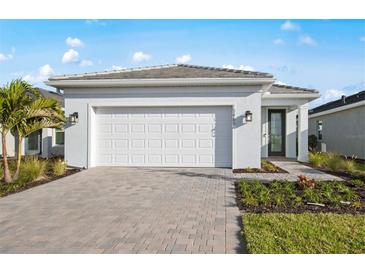 Beautiful one-story home featuring a brick paver driveway and manicured landscaping at 10482 Sea Breeze Ridge Dr, Englewood, FL 34223