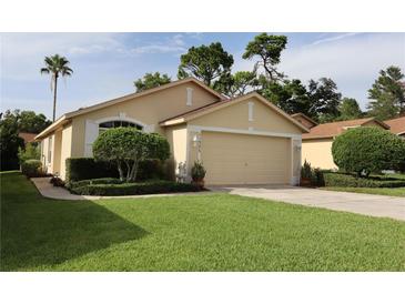 Charming single-story home with a well-manicured lawn and an attached two-car garage at 11323 Highlander Ct, Spring Hill, FL 34609