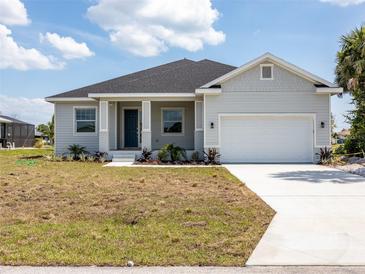 Charming single-story home with a two-car garage, a welcoming front porch, and neatly landscaped front yard at 115 White Marsh Ln, Rotonda West, FL 33947