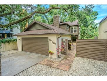 Charming two-story home featuring a garage and quaint landscaping at 13702 Sweetwater Cove Pl # 25, Tampa, FL 33613