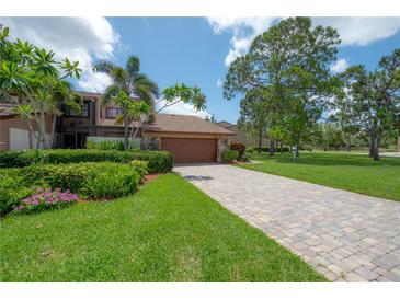 Charming home with lush landscaping, paver driveway, and a welcoming facade at 13851 Lake Point Dr, Clearwater, FL 33762