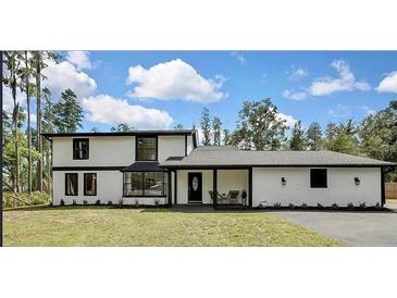 Charming two-story home with white facade, black trim, and a well-manicured lawn at 19003 Cedar Ln, Lutz, FL 33548