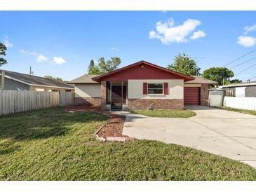 Charming single story home features a red roof, brick accents, and mature landscaping at 2233 Curlew Rd, Dunedin, FL 34698