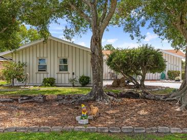 Charming home featuring well-maintained landscaping, mature trees, and a decorative garden gnome accent at 2436 Nuremberg Blvd, Punta Gorda, FL 33983