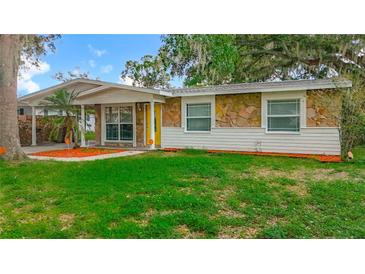 Charming single-story home with a stone facade and a well-manicured lawn at 307 Fern Cliff Ave, Temple Terrace, FL 33617