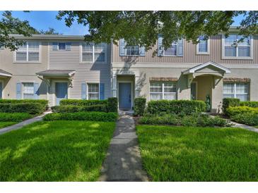 Inviting townhouse with blue shutters, well-manicured lawn, and a charming covered entrance at 5717 Fishhawk Ridge Dr, Lithia, FL 33547