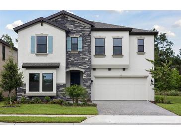 Beautiful two-story home with a stone facade and well-manicured lawn offers great curb appeal at 12758 Oak Hill Way, Parrish, FL 34219