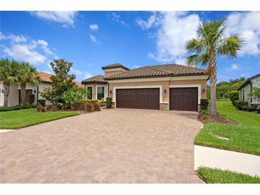 Beautiful single-story home with a paver driveway, lush landscaping and a two-car garage at 3214 Forsythia Dr, Odessa, FL 33556