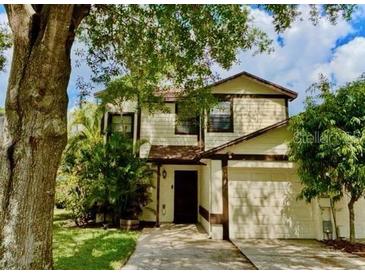 Charming two-story home features a well-manicured lawn, mature trees, and an attached two-car garage at 5110 Corvette Dr, Tampa, FL 33624