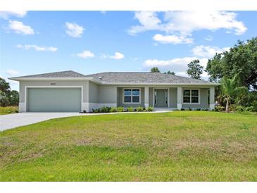 Charming single-story home featuring a well-manicured lawn and a symmetrical front facade at 10237 Deerwood Ave, Englewood, FL 34224