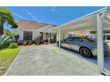 Charming single-story home with a covered carport and meticulously landscaped front yard at 10636 Millriver Dr, New Port Richey, FL 34654