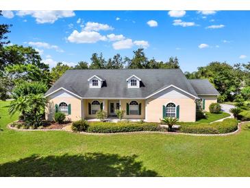 Charming one-story home boasting a well-manicured lawn, green shutters, and a welcoming front porch at 13321 Lewis Raulerson Rd, Dover, FL 33527