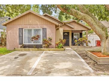 Charming single-story home with brick accents, a cozy porch, and colorful landscaping at 4613 Summerwind Ct, Plant City, FL 33566