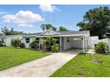 Charming single-story home with a well-manicured lawn, carport, and inviting curb appeal at 6212 S Adelia Ave, Tampa, FL 33616