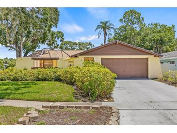 Charming single-story home featuring a two-car garage and lush landscaping for added curb appeal at 8405 Woodbridge Blvd, Tampa, FL 33615