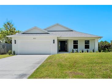 Charming single-story home featuring a two-car garage, manicured lawn and inviting front entrance at 9073 Fruitland Ave, Englewood, FL 34224