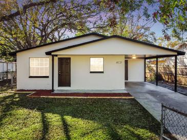 Charming single-story home featuring a carport, fresh exterior paint, and well-manicured lawn at 9312 N Tampa St, Tampa, FL 33612