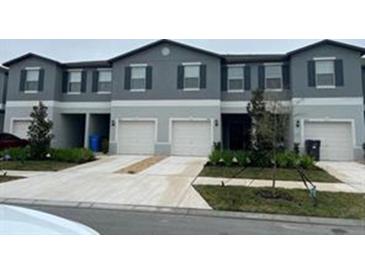 Attractive townhouse featuring a two-car garage, complemented by a well-maintained lawn and simple landscaping at 11847 Dumaine Valley Rd, Riverview, FL 33579