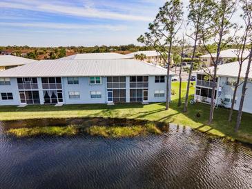Waterfront condo featuring a screened patio with gorgeous views of the pond and lush landscaping at 25050 Sandhill Blvd # 8B1, Punta Gorda, FL 33983
