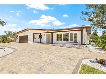 Charming single-story home featuring a meticulously landscaped front yard and brick driveway at 6400 Mockingbird S Way, St Petersburg, FL 33707