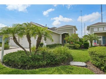 Inviting home exterior featuring a well-manicured lawn and lush tropical landscaping at 13524 Circa Crossing Dr, Lithia, FL 33547