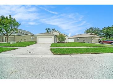 Charming single-story home with a well-manicured lawn and a two-car garage on a sunny day at 247 Winthrop Dr, Spring Hill, FL 34609