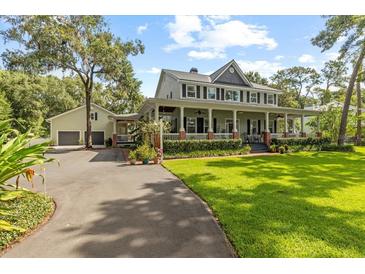 Inviting two-story home with a charming front porch and manicured lawn at 523 2Nd Sw Ave, Lutz, FL 33548