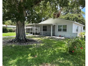 Charming single-story home featuring a screened porch, well-maintained lawn, and mature shade trees at 7651 46Th N Way, Pinellas Park, FL 33781