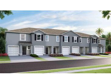 Charming townhomes featuring attached garages and beautifully landscaped front yards at 17465 Spanish Oak Loop, Land O Lakes, FL 34638