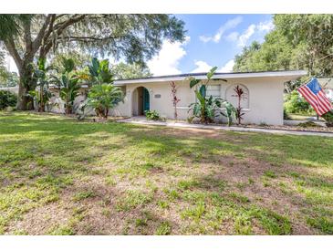 Charming single-story home featuring lush landscaping and an inviting front yard at 35836 Lakeshore Dr, Dade City, FL 33525