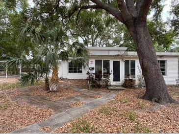 Single story home with tropical landscaping and mature shade tree in the front yard at 4050 Iris N St, St Petersburg, FL 33703