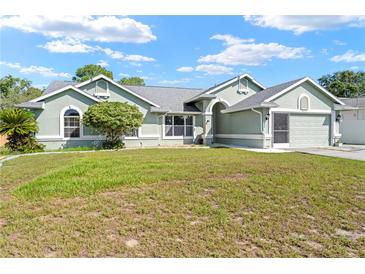 Charming single-story home with well-maintained lawn, mature landscaping, and attached two-car garage at 4399 Dior Rd, Spring Hill, FL 34609