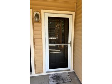 Inviting condo front door with storm door and visible house number at 500 Belcher S Rd # 109, Largo, FL 33771