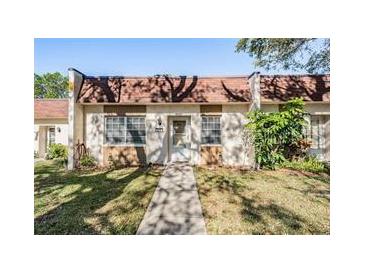 Charming townhome featuring a red tile roof, front yard, and walkway to the front door at 11511 113Th St # 22E, Largo, FL 33778