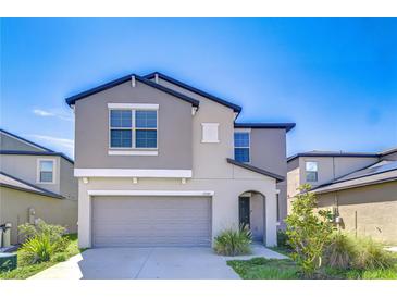 Two-story home featuring gray stucco, a gray garage door, and an arched entryway at 15505 Wicked Strong St, Sun City Center, FL 33573