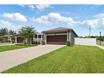 Charming single-story home featuring a spacious driveway and a two-car garage with an adjacent grassy lawn at 288 Villa Corte Dr, Lutz, FL 33549