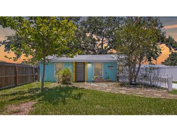 Charming turquoise home featuring a yellow door and manicured landscaping, creating a cheerful curb appeal at 5119 23Rd S Ave, Gulfport, FL 33707