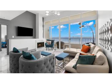 Bright living room with fireplace, ample seating, floor-to-ceiling windows and a waterfront view at 5153 Isla Key S Blvd # 415, St Petersburg, FL 33715