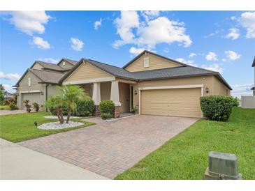 Charming single Gathering home with a two-car garage, beautiful landscaping, and a brick driveway at 11308 Chilly Water Ct, Riverview, FL 33569