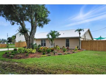 Charming single-story home featuring a metal roof, lush landscaping, and mature trees in a serene neighborhood at 2306 41St E St, Bradenton, FL 34208