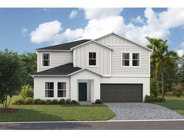 Inviting two-story home featuring a well-manicured lawn and a two-car garage at 36933 Sagemoor Dr, Zephyrhills, FL 33541
