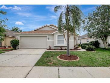 Charming single-story home featuring well-manicured landscaping and a two-car garage at 4129 Marlow Loop, Land O Lakes, FL 34639