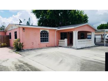 Charming one-story home with a concrete porch, columns, and a well-manicured front yard at 4725 Town N Country Blvd, Tampa, FL 33615