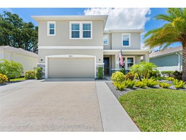 Charming two-story home featuring a neutral facade, a two-car garage, and well-manicured landscaping at 8050 Praise Dr, Tampa, FL 33625