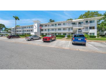 Three-story condo building with white facade, multiple balconies, and parking at 8396 111Th St # 301, Seminole, FL 33772