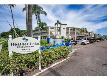 Heather Lake Condominiums exterior view with palm trees and visible parking at 960 Virginia St # 204, Dunedin, FL 34698