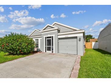 Charming single-story home featuring a well-manicured lawn and attached one car garage at 12413 Dawn Vista Dr, Riverview, FL 33578